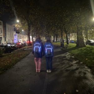 Two teens wearing Futliit LED backpacks at night